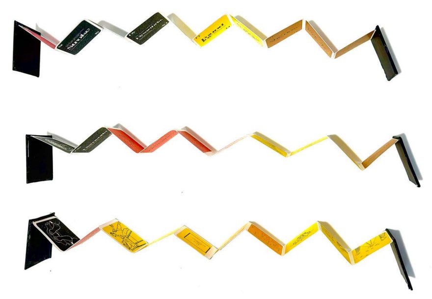 Three fold-out concertina books opened in zigzags, with black covers and pages in black, red, yellow and kraft brown.