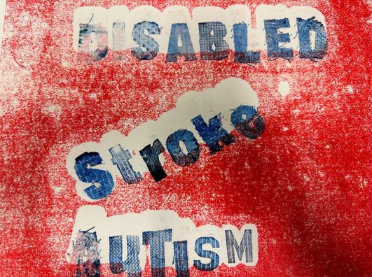 A red monoprint on paper with the words Disabled, Stroke and Autism cut out in blue lettering.